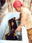 MEWARNAI. Warnai batil tulis berasal dari bahan-bahan alami seperti yang dilakukan salah satu nenek di rumah pengrajin batik Mojokerto ini