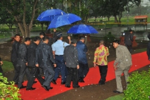 SBY membawa payung sendiri menuju lokasi rencana pembangunan Pusat Informasi Mapahit (PIM) 